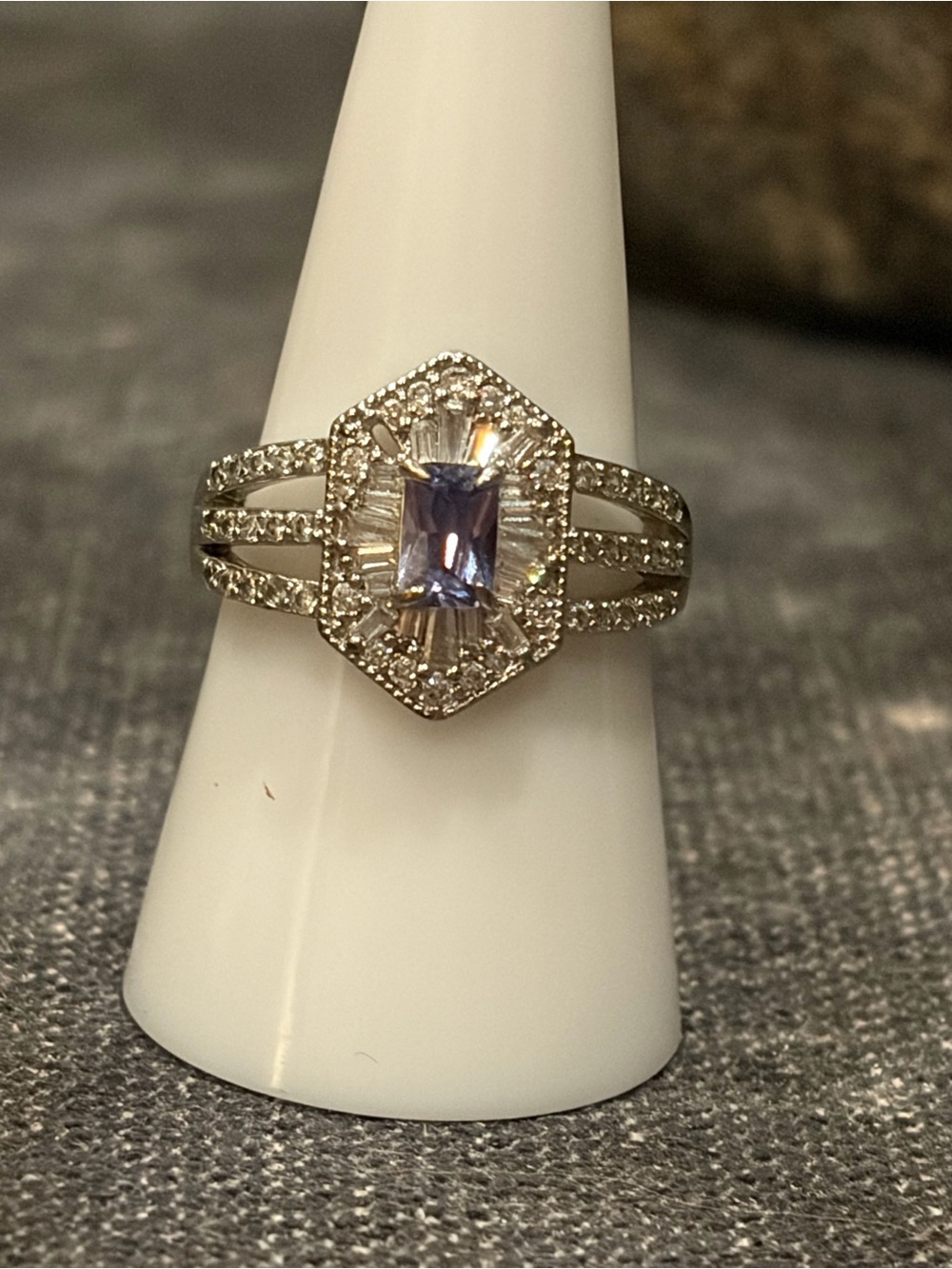 Beautiful Tanzanite Stone Surrounded by Pave CZ’s on Rhodium Plated Band
